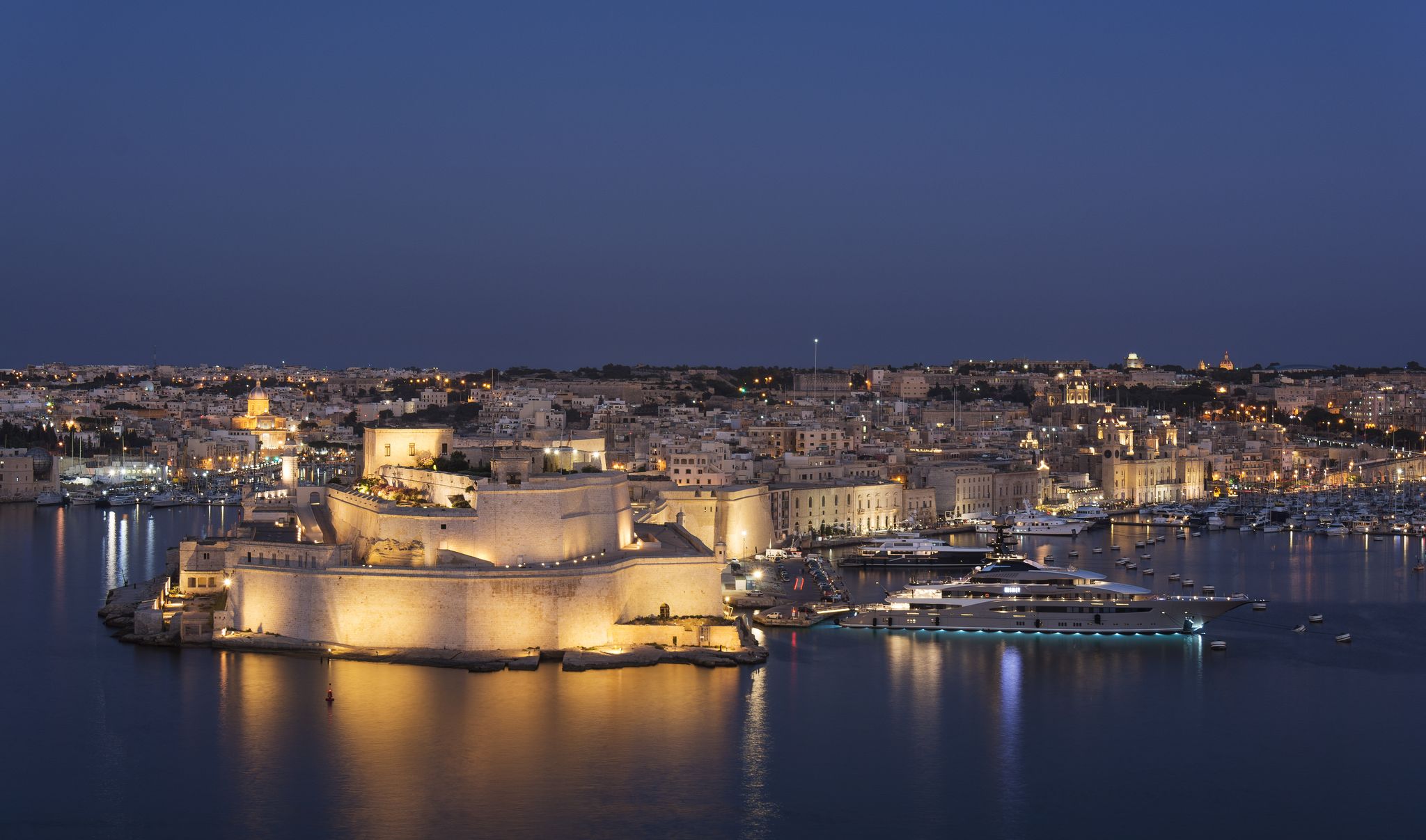 Photo of aerial view of Fort Saint Angelo of Birgu at night in Malta from the sea.