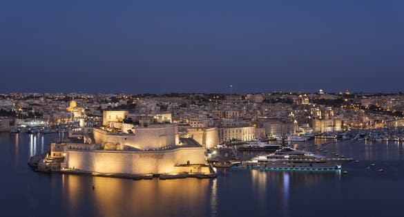 Photo of aerial view of Fort Saint Angelo of Birgu at night in Malta from the sea.