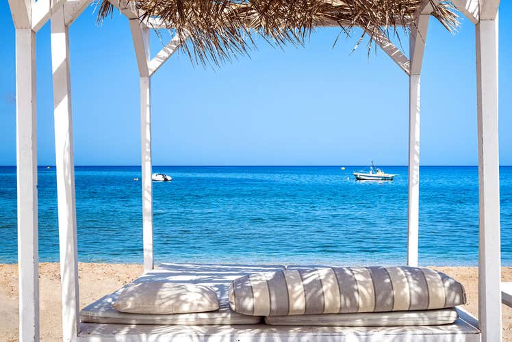 Photo of view to the summer blue sea from the gazeboo with thatch roof, Analipsi ,Greece.