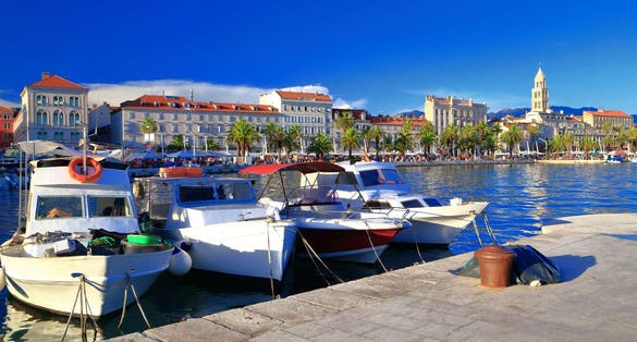 Photo of Adriatic sea coast with small boats tied to the pier in traditional town, Split, Croatia.