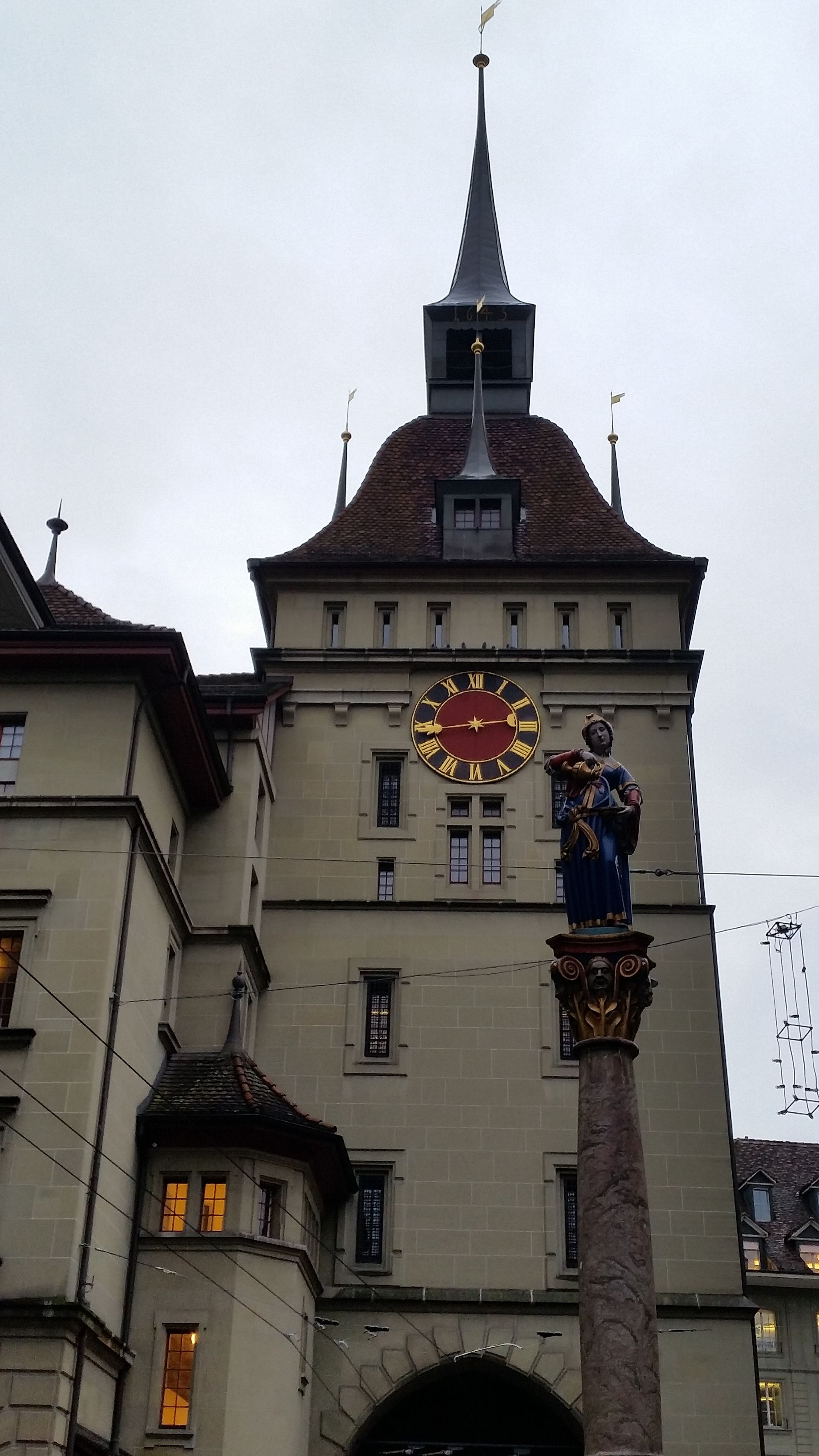 photo of medieval tower Käfigturm with Anna Seiler Fountain in Bern, Switzerland.