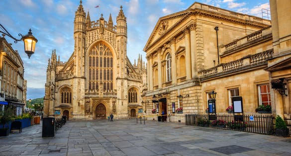 Photo of historic Bath Abbey and roman baths building in Bath Old town center, England.