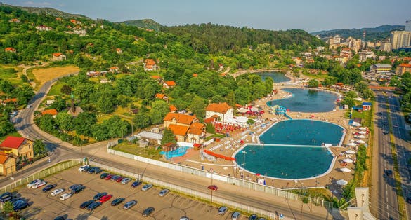 An aerial shot of the cityscape of Tuzla, Bosnia, with buildings and swimming pools with its parking lot with cars