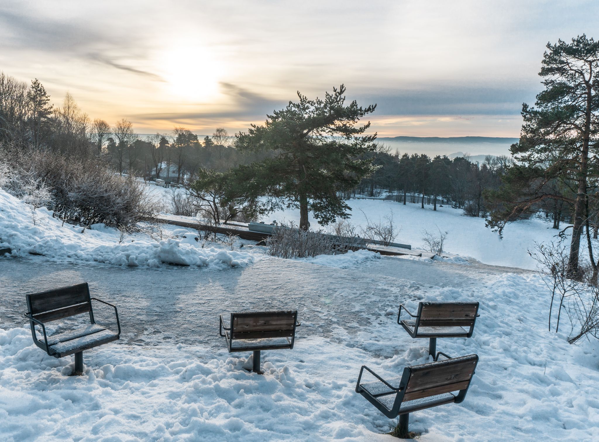 Observation deck with empty icy chairs. Winter day in the Ekeberg park. Ekeberg is a neighborhood in the city of Oslo