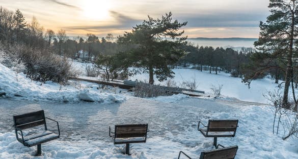 Observation deck with empty icy chairs. Winter day in the Ekeberg park. Ekeberg is a neighborhood in the city of Oslo