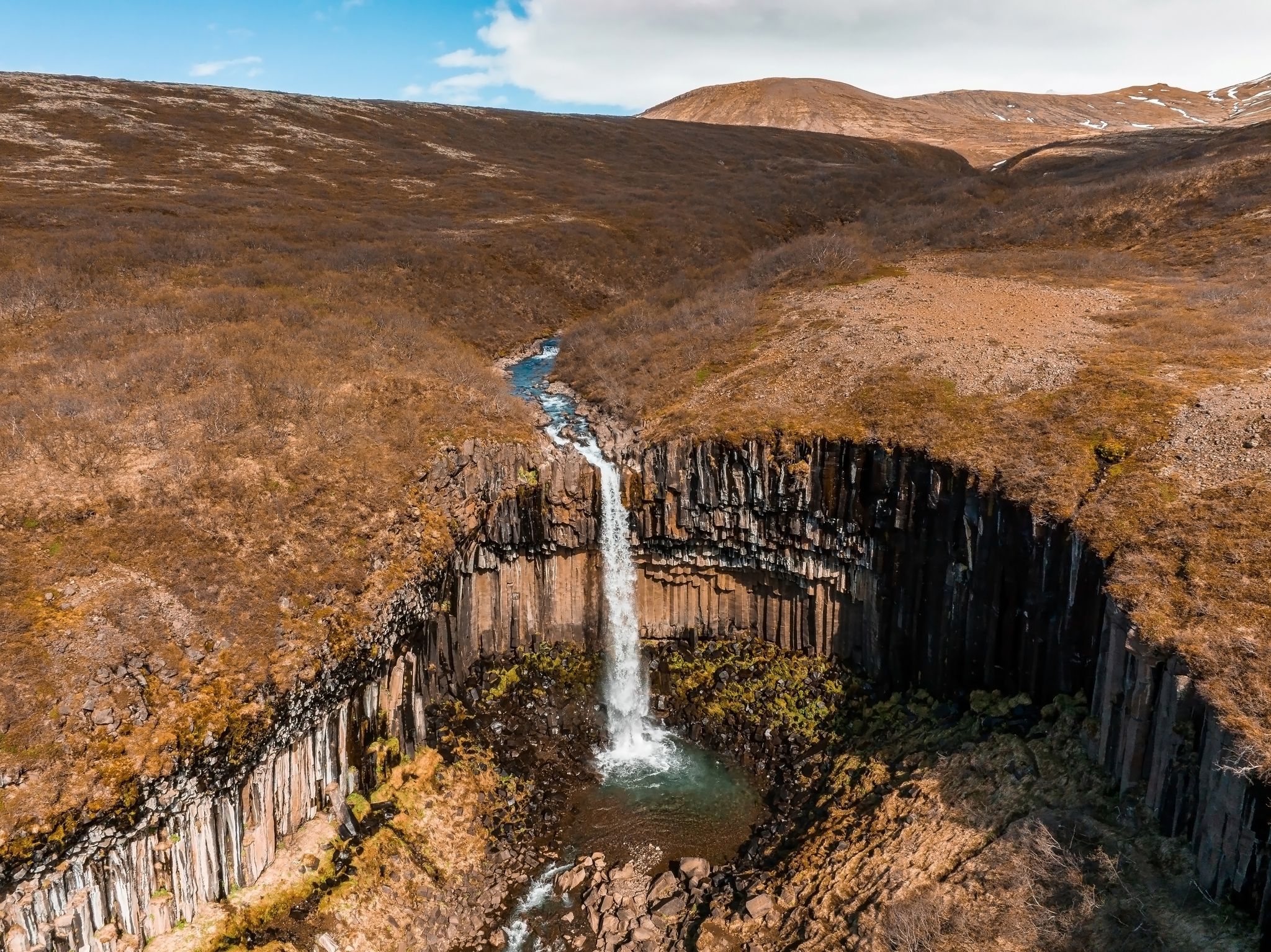photo of aerial view of the svartifoss waterfall surrounded by basalt columns in the south of Iceland. Beautiful Icelandic nature.