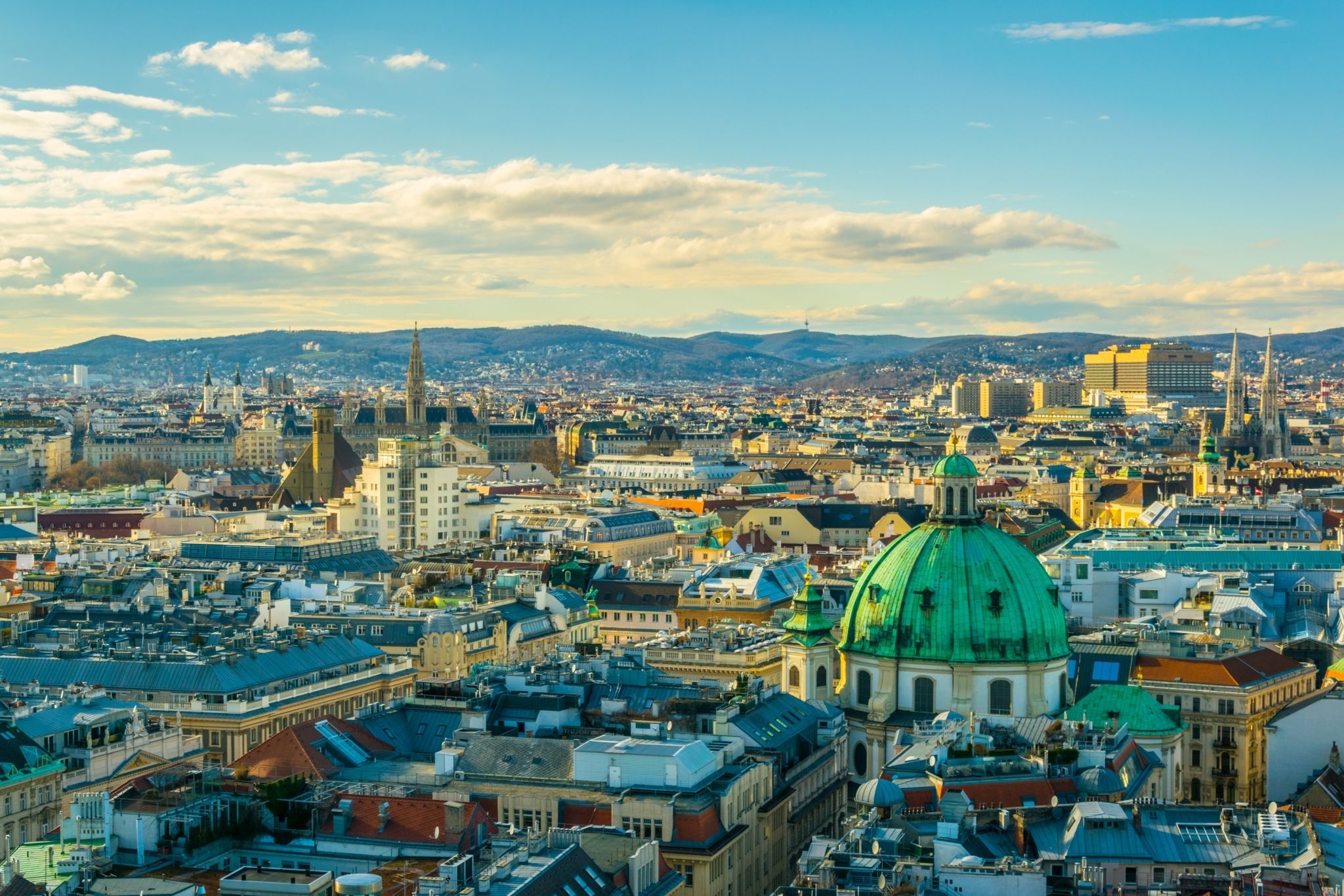 photo of Aerial view of Vienna with tower of the town hall building, votivkirche and peterskirche churches from the stephansdom cathedral, Vienna, Austria.