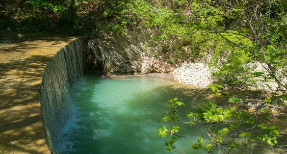 PHOTO OF Beautiful waterfall in the famous wood of Saint Francis in Assisi, umbria region, Italy