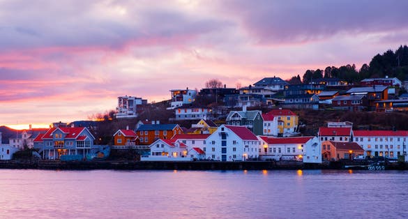 photo of view of Kristiansund, Norway. View of city center of Kristiansund, Norway during the cloudy morning at sunrise with colorful sky. Port with historical buildings