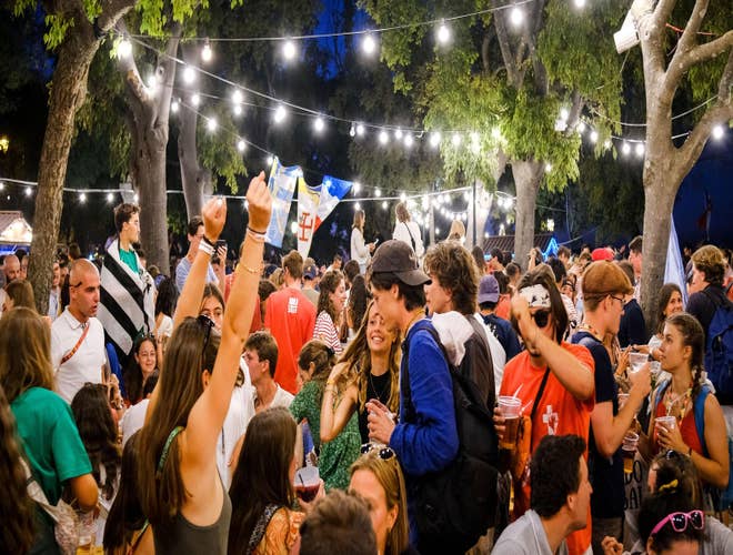 Young crowds celebrating under string lights at a lively outdoor festival in Portugal in August..jpg