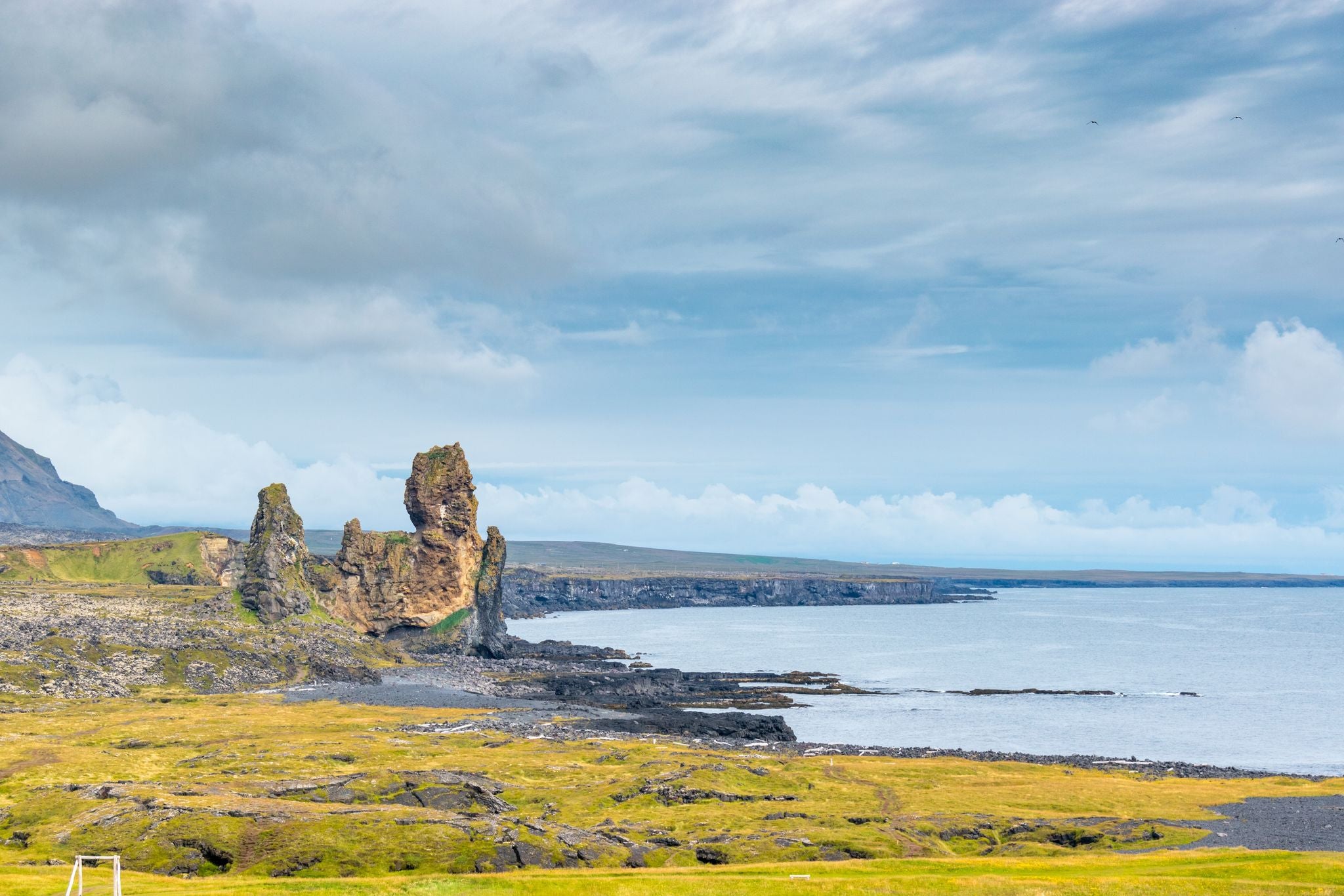 photo of view of Lóndrangar basalt pinnacles, on the southern coast of the Snæfellsnes Peninsula, Iceland.