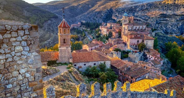 photo of view of Views of Albarracin at sunset with its walls and the church of Santa Maria y Santiago in the foreground. Teruel, Spain.
