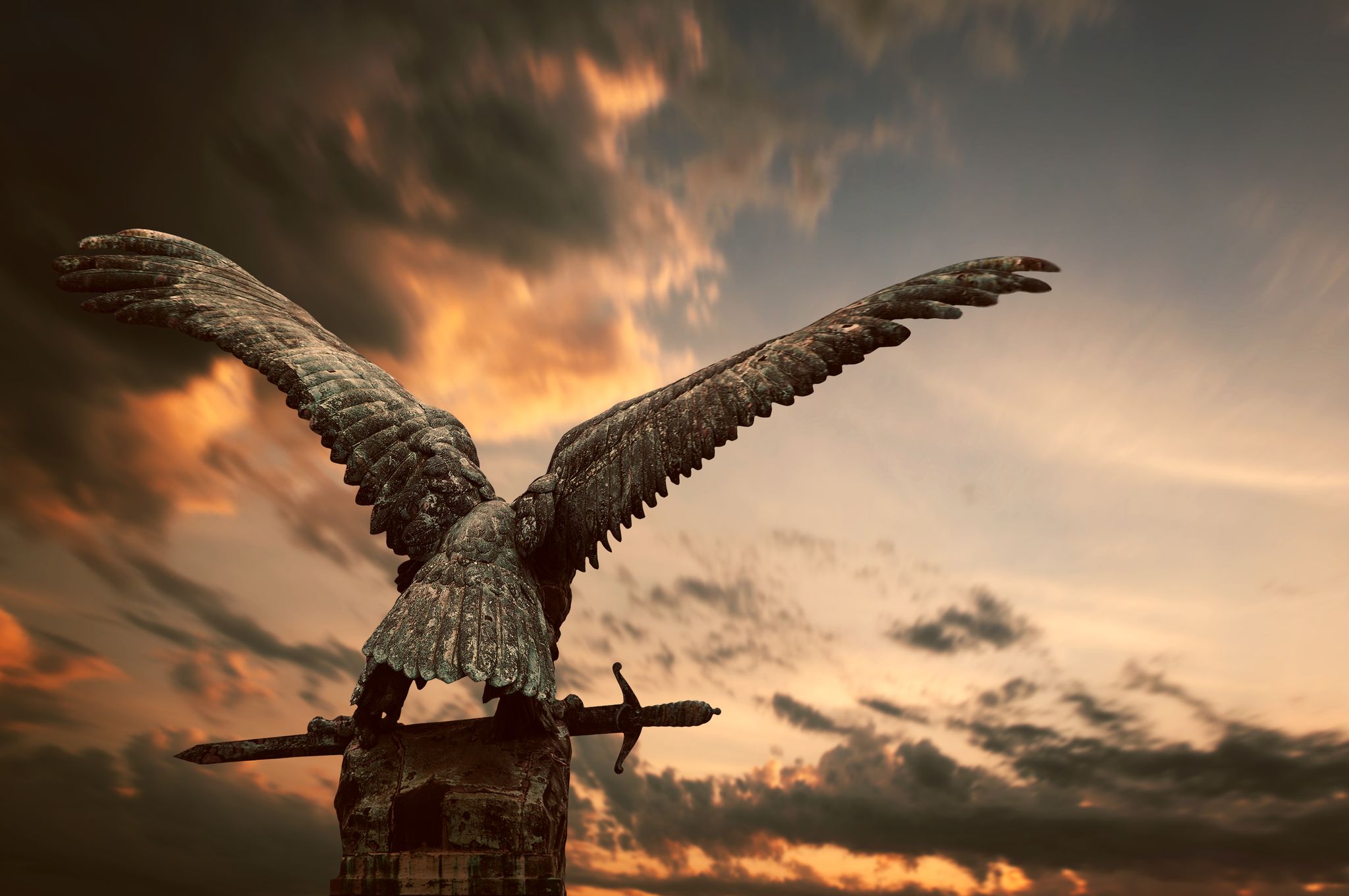 photo of view of Turul bird with a sword with apocalyptic sky in the Royal Castle, Budapest, Hungary.