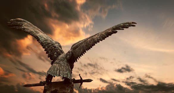 photo of view of Turul bird with a sword with apocalyptic sky in the Royal Castle, Budapest, Hungary.