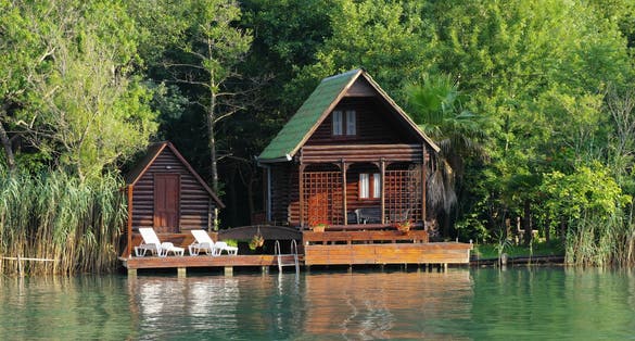 Photo of wooden house along the lush Ada Bojana riverside, Montenegro.