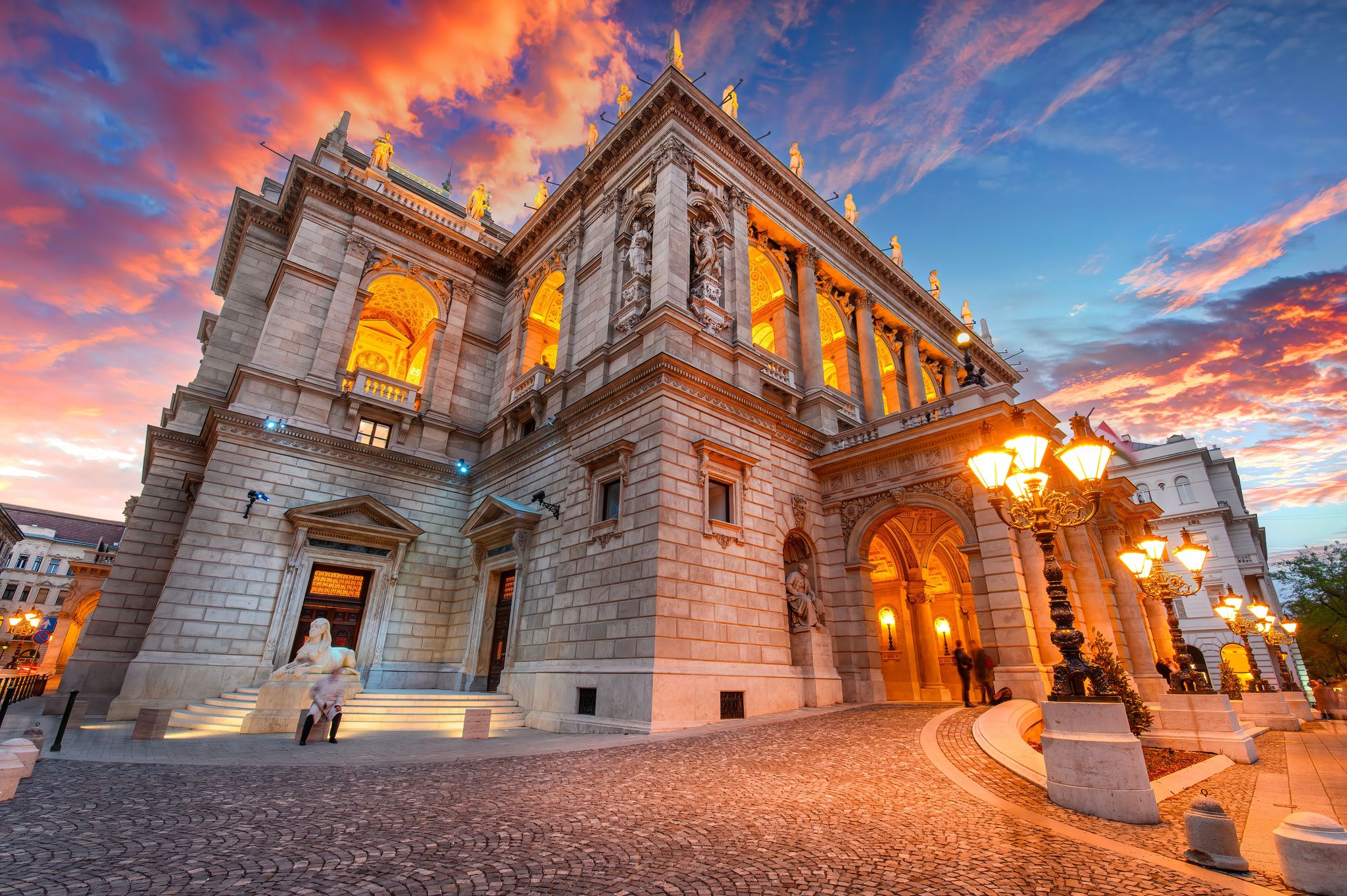 photo of view of  The Hungarian Royal State Opera House in Budapest, Hungary at sunset, considered one of the architect's masterpieces and one of the most beautiful in Europe.