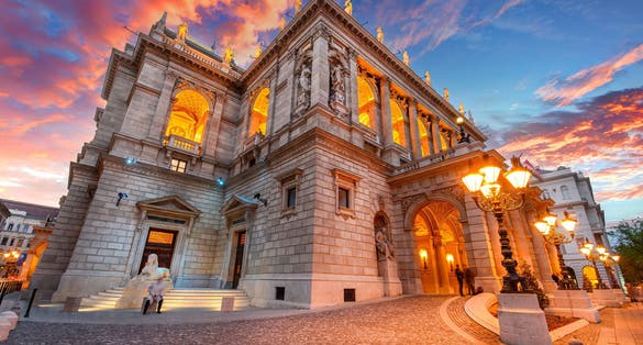 photo of view of  The Hungarian Royal State Opera House in Budapest, Hungary at sunset, considered one of the architect's masterpieces and one of the most beautiful in Europe.