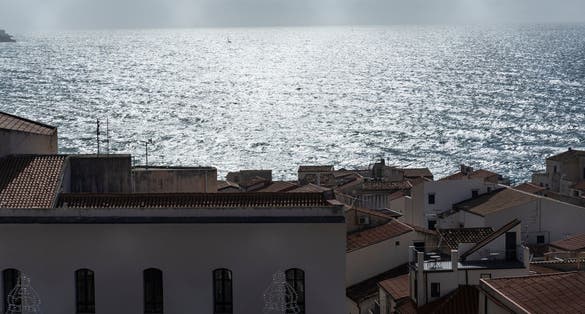 photo of View of Cefalù, the city, the cathedral and its castle. Panorama seen from above of the whole landscape. Rough sea during sunset. The most beautiful places in Sicily. Excellent tourist destination.