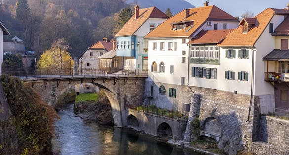 Photo of Capuchin Bridge in Skofja Loka over Selska Sora river, medieval town in Slovenia in autumn time.