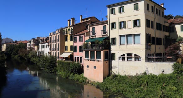 Houses and apartment buildings along the Brenta river seen from the Ponte Molino bridge in Padua, Italy