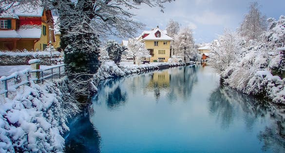Photo of Interlaken idyllic landscape after snow in winter with river reflection, Swiss alps, Switzerland .