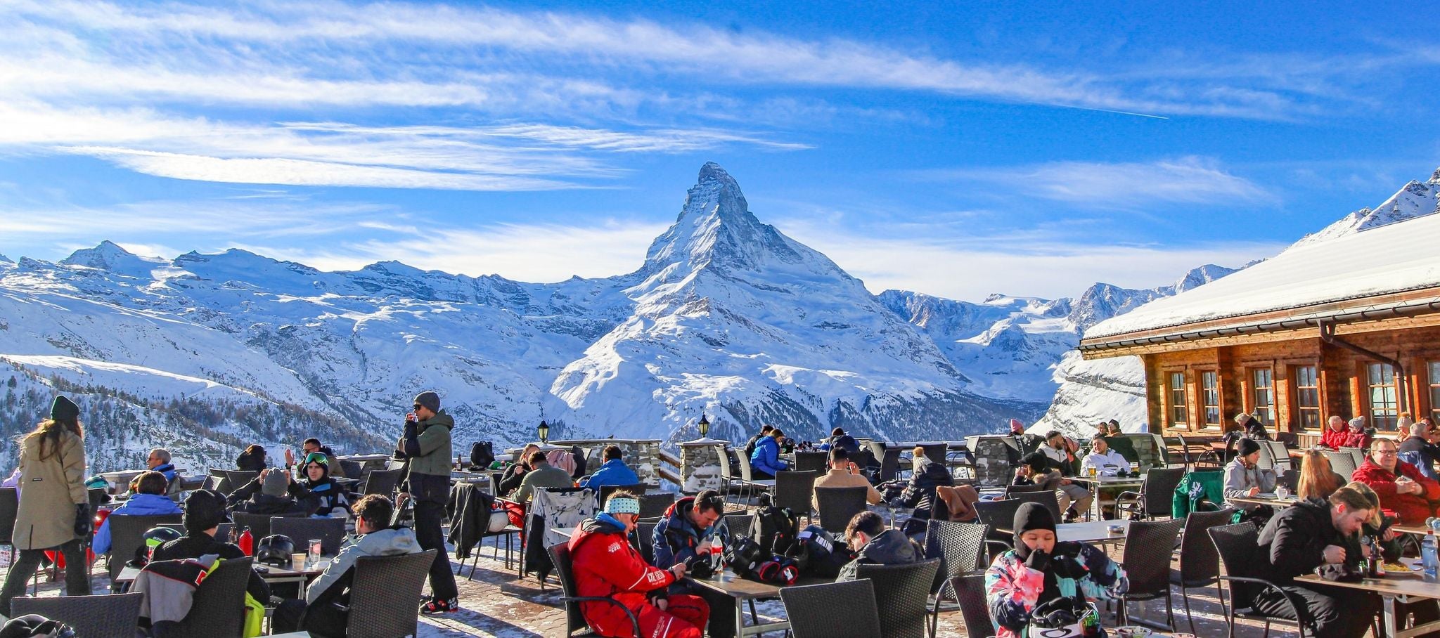 Winter tourists dining outdoors with the Matterhorn and snowy Alps in Zermatt, Switzerland..jpg