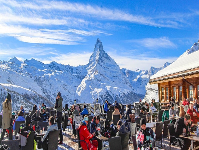 Winter tourists dining outdoors with the Matterhorn and snowy Alps in Zermatt, Switzerland..jpg