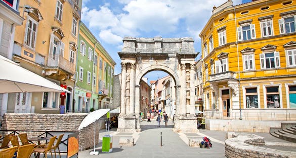Photo of Golden Roman Gate (Sergius Arch) in Pula at sunny day, Croatia.