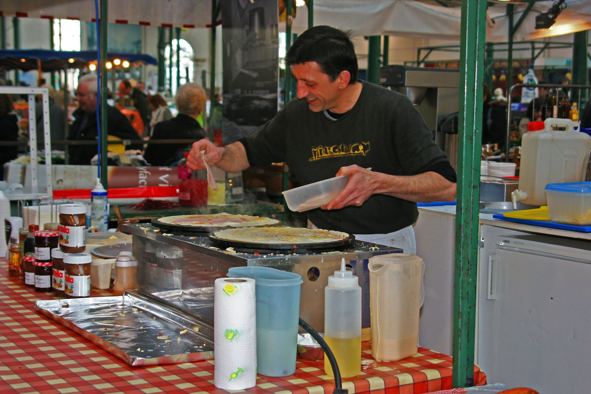 A busy Pizza Chef caught on the move while cooking in the St Georges covered market in Belfast, Northern Ireland.
