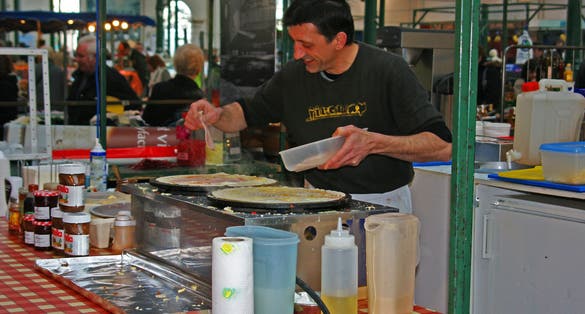 A busy Pizza Chef caught on the move while cooking in the St Georges covered market in Belfast, Northern Ireland.