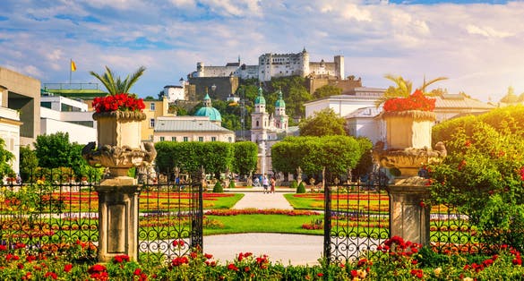 Photo of beautiful view of famous Mirabell Gardens with the old historic Fortress Hohensalzburg in the background in Salzburg, Austria.