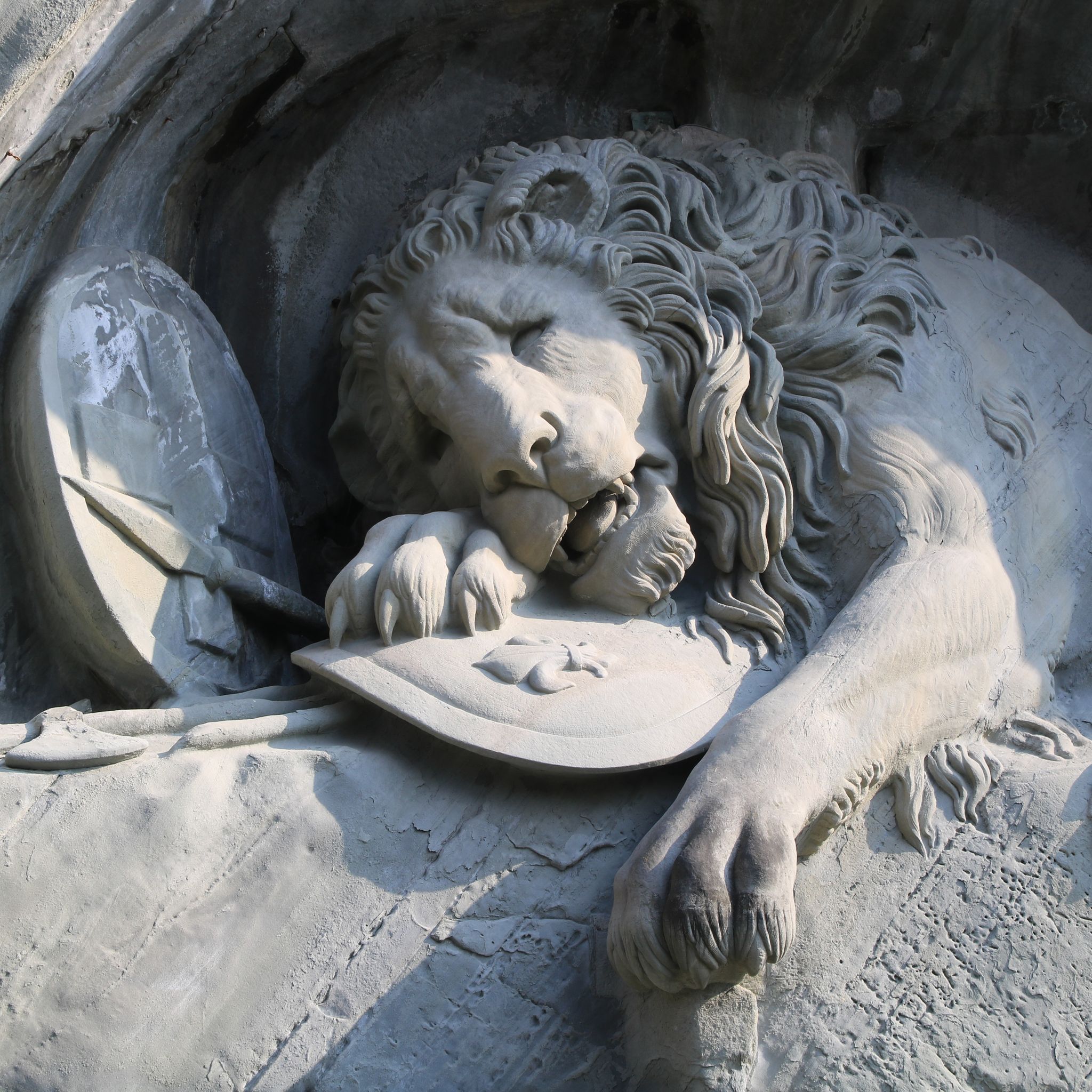 Photo of detail of the Lion Monument, Lucerne ,Switzerland. Carved in stone, yet deceptively alive, Lucerne’s world famous Lion Monument has been impressing visitors from near and far for a long time.