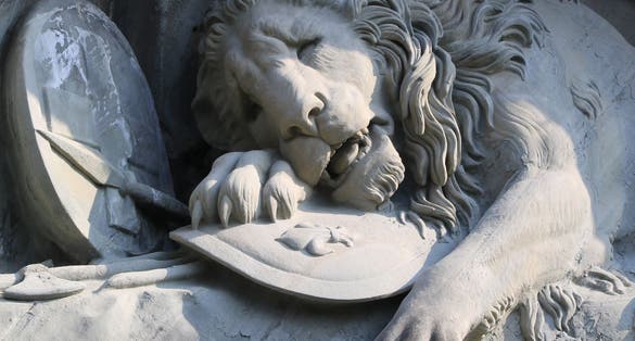 Photo of detail of the Lion Monument, Lucerne ,Switzerland. Carved in stone, yet deceptively alive, Lucerne’s world famous Lion Monument has been impressing visitors from near and far for a long time.