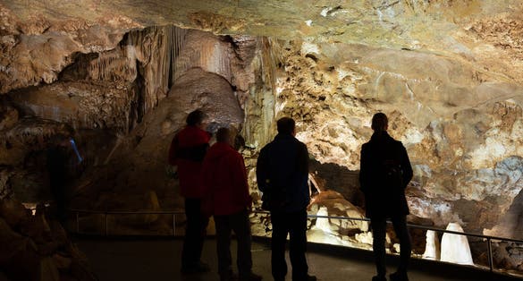 Photo of natural rock formations with tourists in Koneprusy Caves, Central Bohemian Region, Czech Republic.