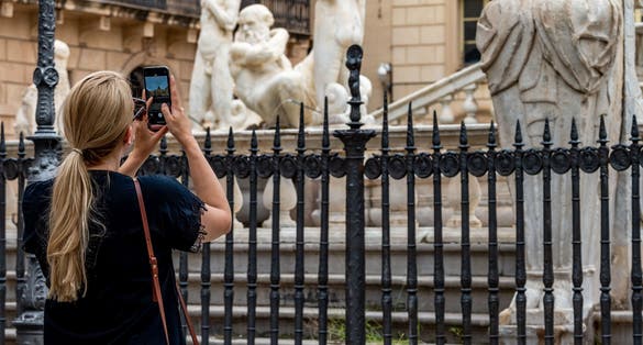 photo of Photo of a tourist taking pictures of the beautiful Fontana Pretoria also known as the square of shame for its nude statues in the heart of Palermo .