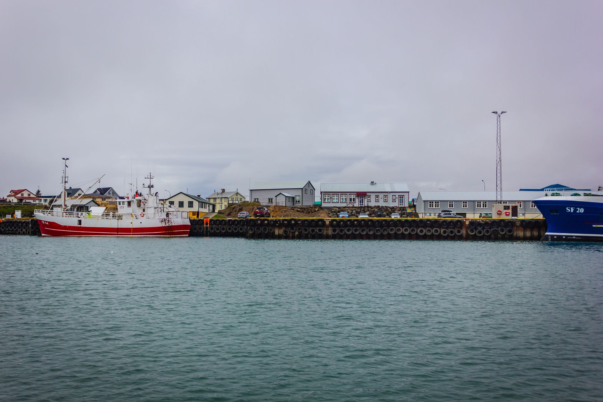 photo of view of Harbor with boats and buildings with cloudy sky, Höfn, Southeast Iceland.