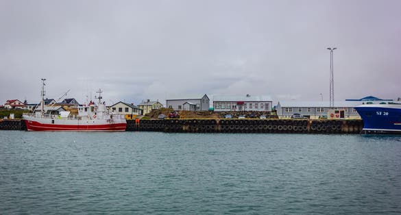 photo of view of Harbor with boats and buildings with cloudy sky, Höfn, Southeast Iceland.
