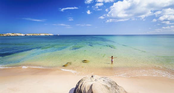 Photo of woman on the beach in Portugal celebrate a wonderful day.