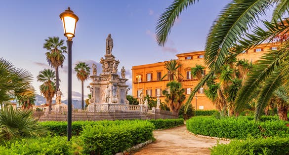 Photo of Villa Bonnano public gardens and the palace at dawn.
