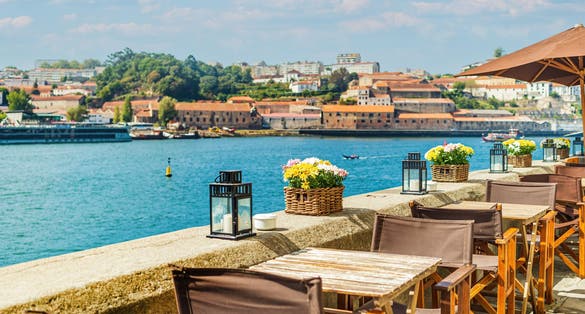 Photo of beautiful view of open-air street cafe on the banks of the River Douro in Porto, Portugal.