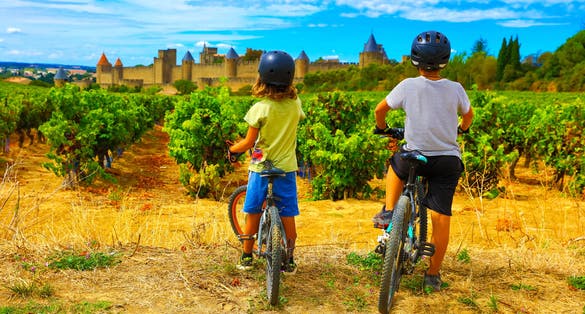 Photo of two children looking at beautiful castle of Carcassonne in France.