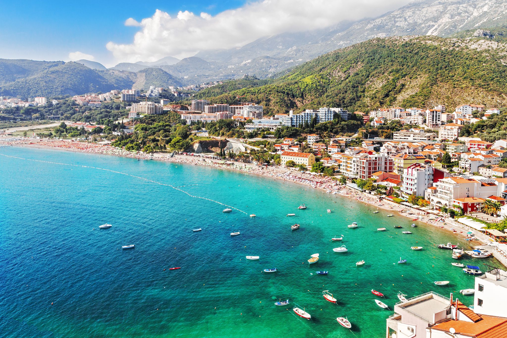 Photo of Becici town and beach in Montenegro , Sun umbrellas and loungers at the sandy beach. 