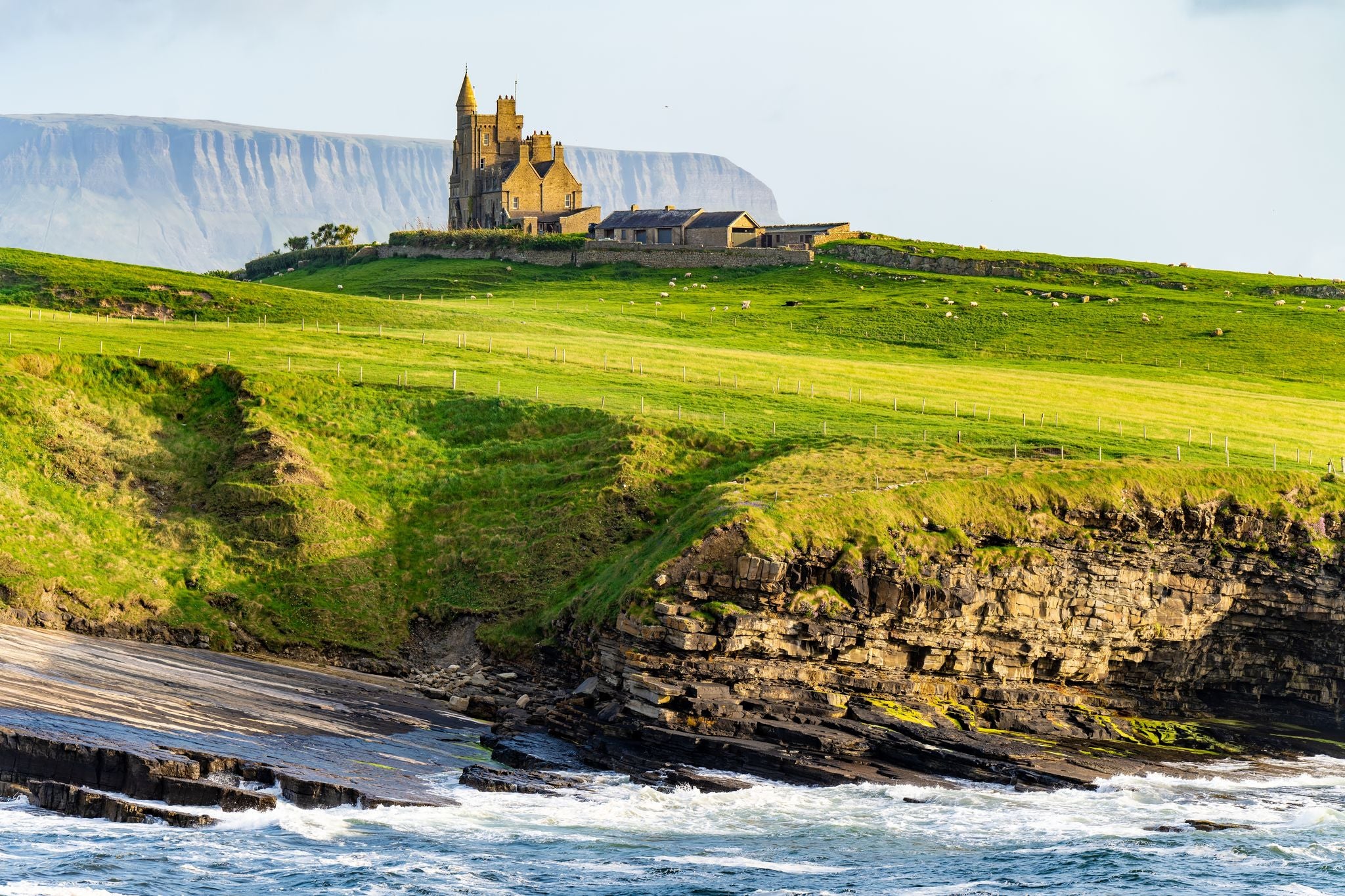 photo of view of Famous Classiebawn Castle in picturesque landscape of Mullaghmore Head. Spectacular sunset view with huge waves rolling ashore. Signature point of Wild Atlantic Way, Co. Sligo, Ireland