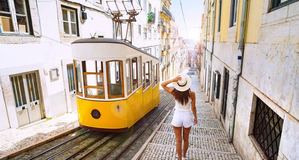 Photo of Woman tourist walking in narrow streets of Lisbon city old town. 