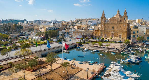 Photo of Aerial view of Msida marina bay and church. Sunny day, Maltese and Europe flags. Malta island.