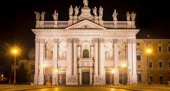 photo of view of The papal archbasilica (or basilica) of St John in the Lateran, in Rome,, Italy, lit in the dark night., Rome, Italy.