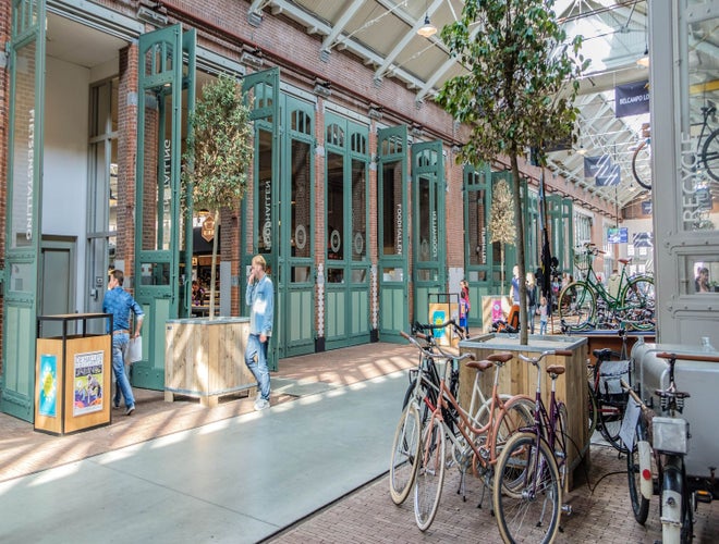 People walking and cycling near the entrance of De Hallen food market in Amsterdam..jpg