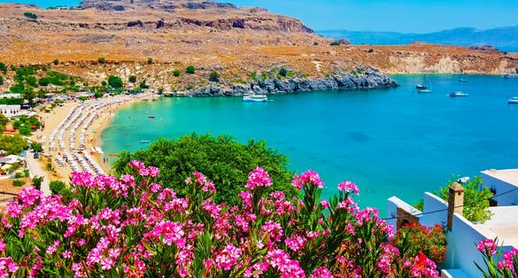 Photo of view of Lindos Bay with flowers. Lindos, Rhodes, Dodecanese Islands, Greece, Europe