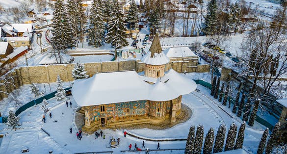 Photo of aerial view of the Voronet Monastery in winter one of Romanian Orthodox monasteries in southern Bucovin, Romania.