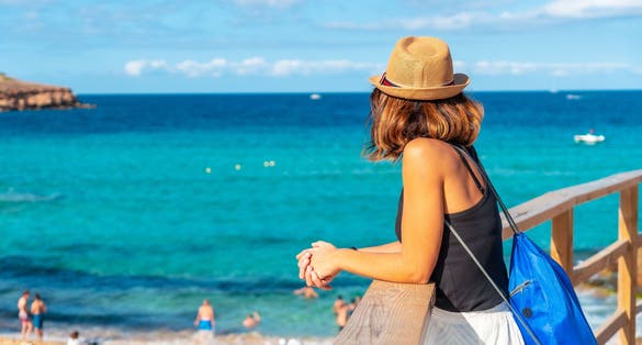 Photo of a tourist enjoying the peace at Cala Comte beach on the island of Ibiza.